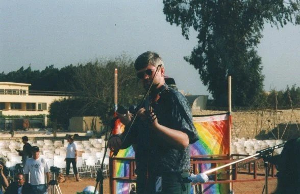 Adam Sweet playing fiddle on stage at Giza